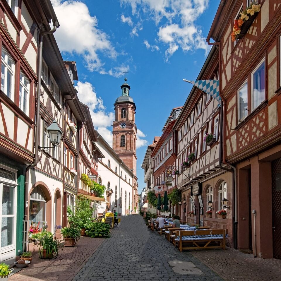 Die Hauptstraße von Miltenbergs Altstadt mit Fachwerkhäusern und der St. Jakobuskirche im Hintergrund.